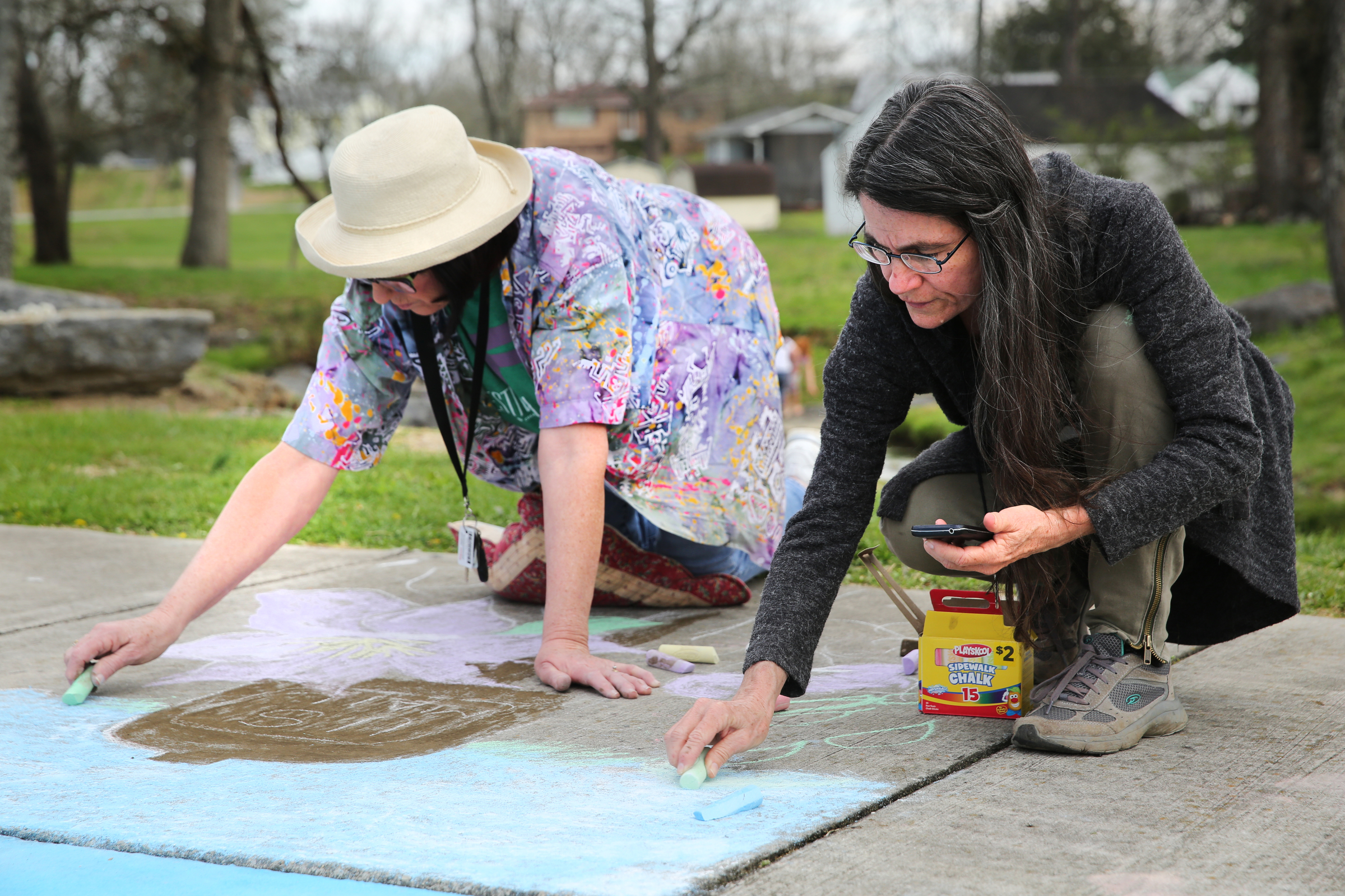 Sandra Babb and Melinda Lee create a sidewalk chalk drawing featuring a mailbox and flowers at Gilbert-Stephenson Park during a Thriving Communities Initiative interactive art walk pop-up event Sunday, March 18, 2018 in Fort Oglethorpe, Ga. The Thriving Communities Initiative helps Fort Oglethorpe leaders and volunteers enhance life in the city through arts and culture.