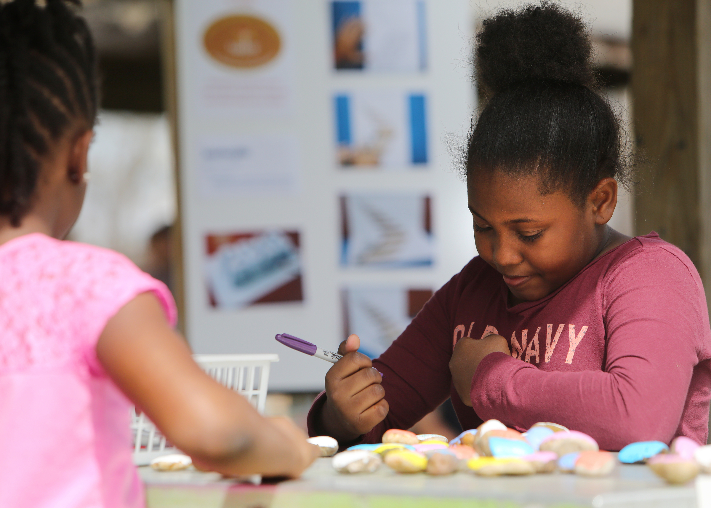 Bryonna Calhoun, 9, admires a drawing of her face that she created on a rock at Gilbert-Stephenson Park during a Thriving Communities Initiative interactive art walk pop-up event Sunday, March 18, 2018 in Fort Oglethorpe, Ga. Fort Oglethorpe is one of four cities chosen this year by the Thrive Regional Partnership to receive strategic assistance for the next 10 months from Bridge Innovate design professionals and other community members.
