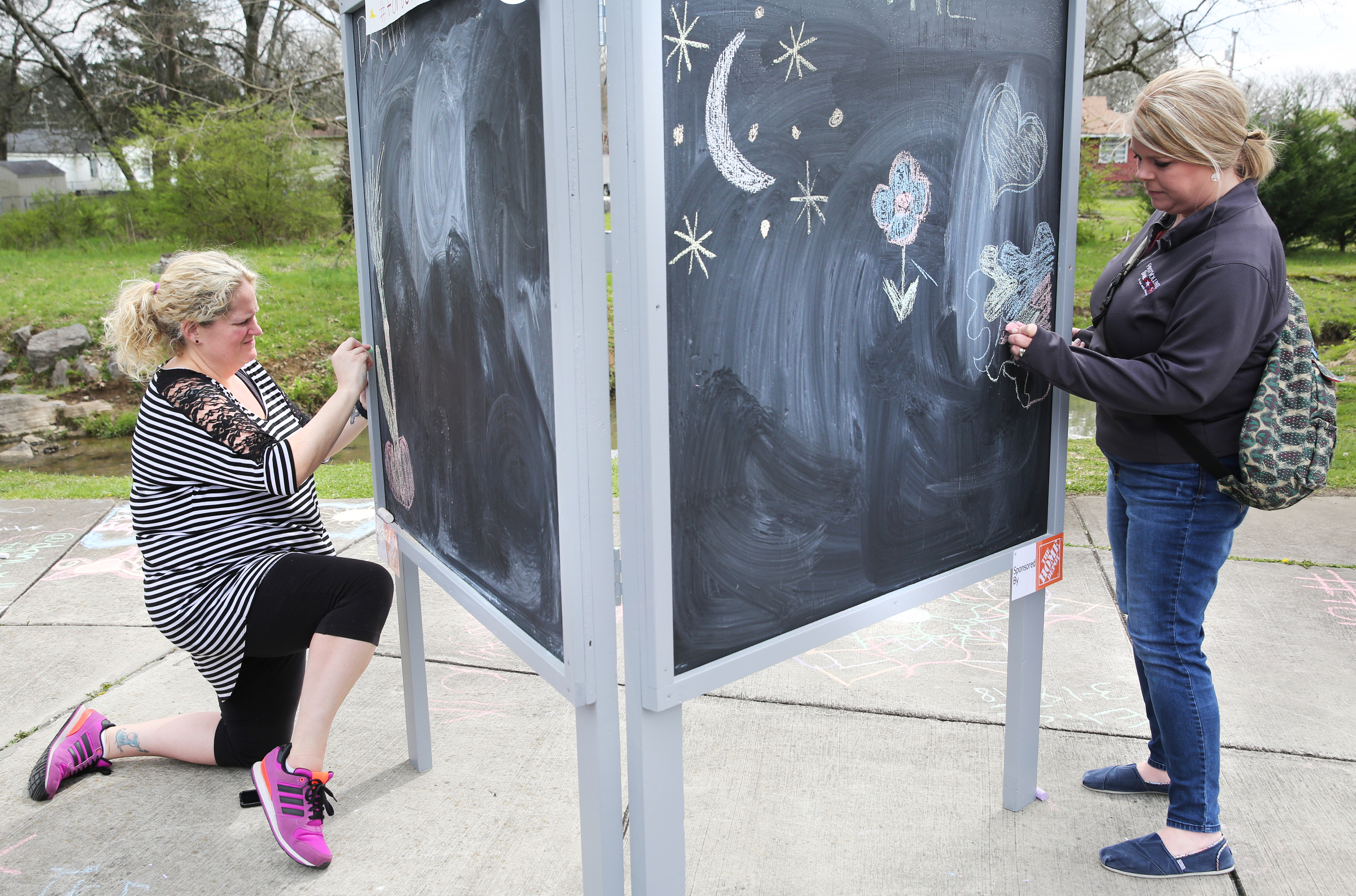 Nicole Hill, a volunteer for the Fort Oglethorpe Thriving Communities Initiative, and Alice Holsopple work on chalk drawings at Gilbert-Stephenson Park during a Thriving Communities Initiative interactive art walk pop-up event Sunday, March 18, 2018 in Fort Oglethorpe, Ga. Fort Oglethorpe leaders and volunteers were using the sidewalk chalk art to test the idea of public displays of art along walking trails that could be extended throughout the city.
