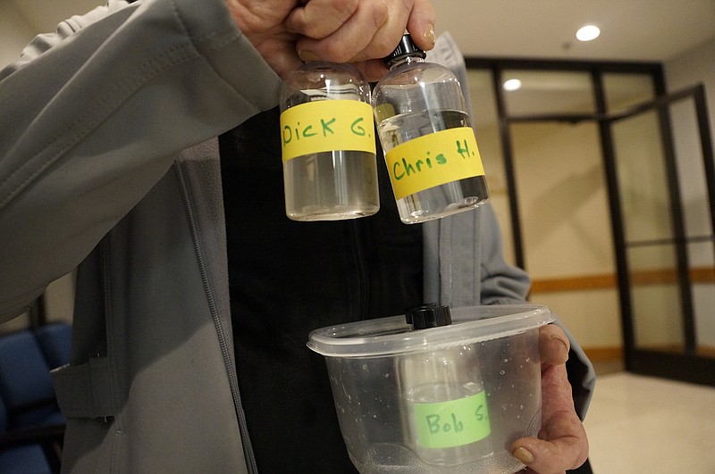 Signal Mountain resident Claire Gresinger holds up samples of water she collected from Tennessee American Water company's source, the Tennessee River, and water she collected from Walden's Ridge Utility District's source, an underground aquifer. Since WRUD's water, right, is clearer, she says, it requires less filtration before it is safe to drink. (Contributed photo)