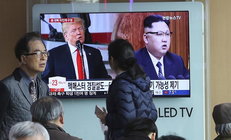 In this March 17, 2018, photo, people pass by a TV screen showing North Korean leader Kim Jong Un, right, and U.S. President Donald Trump during a news program at the Seoul Railway Station in Seoul, South Korea. Top U.S., South Korean and Japanese officials have discussed how to achieve a complete denuclearization of the Korean Peninsula ahead of upcoming inter-Korean and U.S.-North Korean summit talks. The signs read: " The possible reshuffle of U.S. National Security Adviser H.R. McMaster." (AP Photo/Ahn Young-joon)