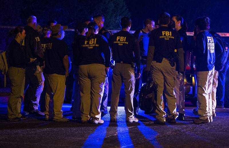 FBI agents meet at the scene of an explosion in Austin, Texas, Sunday, March 18, 2018. At least a few people were injured in another explosion in Texas' capital late Sunday, after three package bombs detonated this month in other parts of the city, killing two people and injuring two others. (Nick Wagner/Austin American-Statesman via AP)