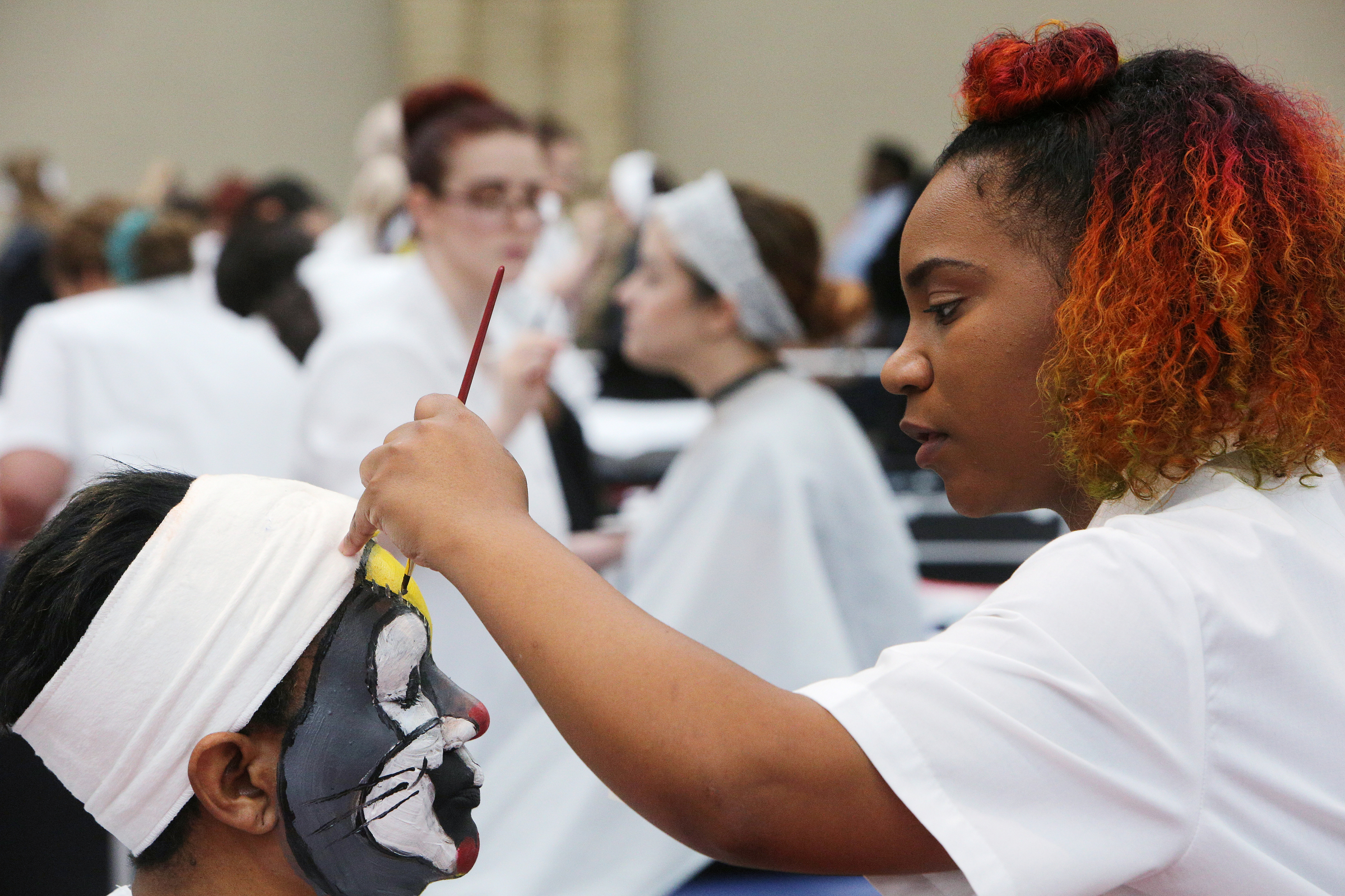 Crystal Foster sits still while Peitra Hamilton paints Foster's face for a competition during the Tennessee State Leadership and Skills Conference at the Chattanooga Convention Center on Tuesday, March 20, 2018 in Chattanooga, Tenn. Foster and Hamilton are students at the Tennessee College of Applied Tech-Memphis.
