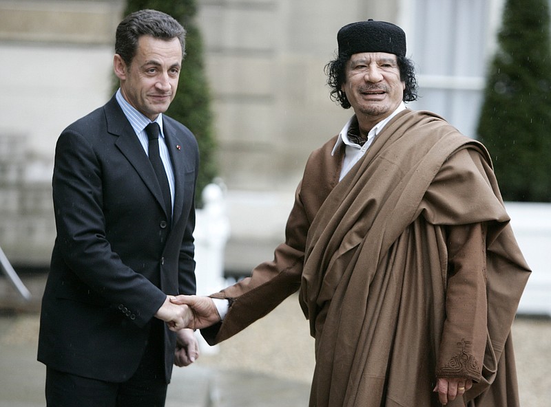 In this Dec. 10 2007 file photo, French President Nicolas Sarkozy, left, greets Libyan leader Col. Moammar Gadhafi upon his arrival at the Elysee Palace, in Paris. Former French President Nicolas Sarkozy was placed in custody on Tuesday March 20, 2018as part of an investigation that he received millions of euros in illegal financing from the regime of the late Libyan leader Moammar Gadhafi. (AP Photo/Francois Mori)