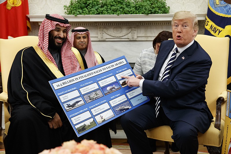 President Donald Trump shows a chart highlighting arms sales to Saudi Arabia during a meeting with Saudi Crown Prince Mohammed bin Salman in the Oval Office of the White House, Tuesday, March 20, 2018, in Washington. (AP Photo/Evan Vucci)