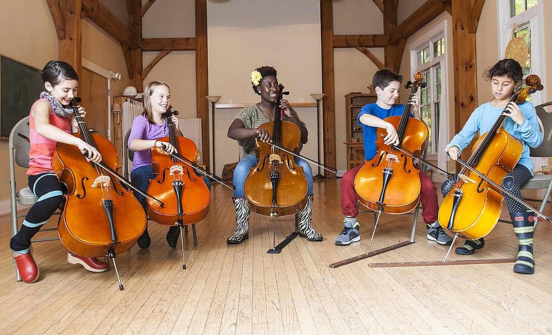 It was while teaching at Oak Ridge High School after graduating from the University of Tennessee at Knoxville that Marshunda Smith, center, decided she wanted to teach young musicians. She is shown here with a class in Boston. (Photo by Kim Indresano)