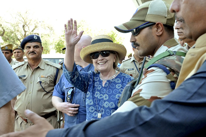 Former U.S. Secretary of State Hillary Clinton, center, waves as she comes out of the Jodhpur airport upoon her arrival in Jodhpur, Rajasthan state, India, Tuesday, March 13, 2018. (AP Photo/Sunil Verma)