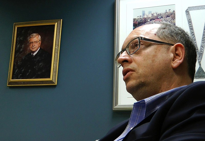 In this March 20, 2018, frame from video, Jefferson County Circuit Judge Robert Vance talks in his office in Birmingham, Ala., near a portrait of his father, slain U.S. Circuit Judge Robert S. Vance. The elder Vance was killed by a package bomb delivered to his home in 1989, and Vance says he feels empathy for victims of a string of bombings in Austin, Texas. (AP Photo/Jay Reeves)