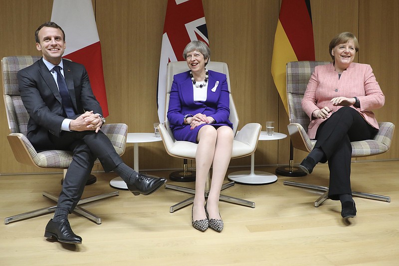 British Prime Minister Theresa May, center, German Chancellor Angela Merkel, right, and French President Emmanuel Macron, left, meet on the sidelines of an EU summit at the Europa building in Brussels on Thursday, March 22, 2018. (Ludovic Marin, Pool Photo via AP)