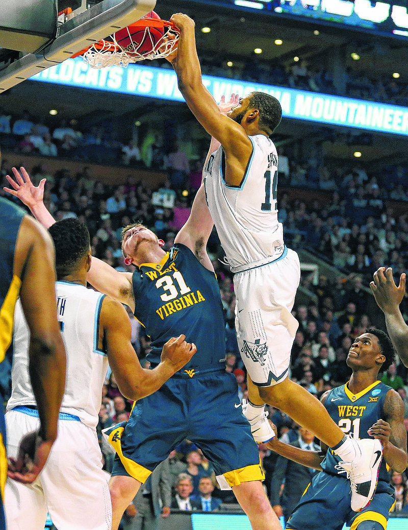 Villanova's Omari Spellman, right, dunks over West Virginia's Logan Routt during the second half of an NCAA men's college basketball tournament regional semifinal Friday, March 23, 2018, in Boston. (AP Photo/Mary Schwalm)