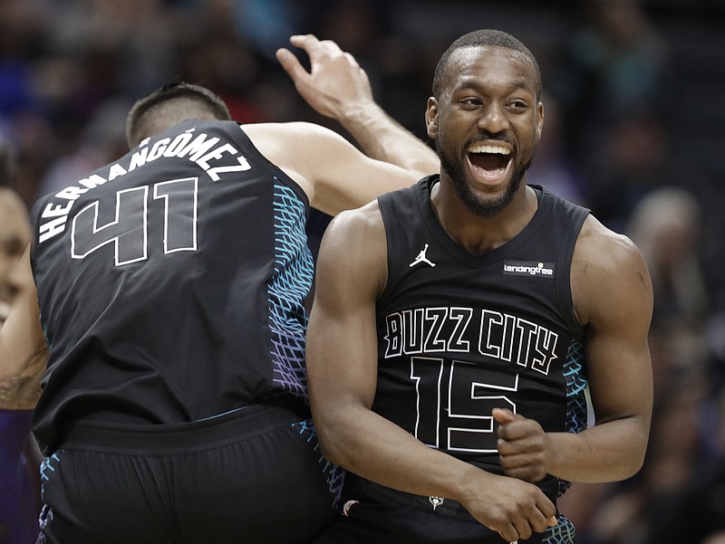 Charlotte Hornets' Kemba Walker (15) celebrates with Willy Hernangomez (41) during the second half of an NBA basketball game against the Memphis Grizzlies in Charlotte, N.C., Thursday, March 22, 2018. (AP Photo/Chuck Burton)