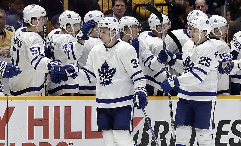 Toronto Maple Leafs center Auston Matthews (34) is congratulated after scoring a goal against the Nashville Predators in the second period of an NHL hockey game Thursday, March 22, 2018, in Nashville, Tenn. Maple Leafs left wing James van Riemsdyk (25) looks on. (AP Photo/Mark Humphrey)