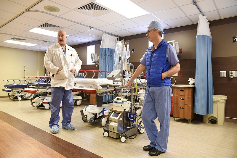 Staff photo by Tim Barber Cardiothoracic surgeon Dr. Larry Shears, right, and Dr. Philip Smith, a trauma and critical care surgeon, talk about the life-saving ECMO machine that was used at Erlanger Health System during the flu season of 2017-2018. The ECMO oxygenates blood and serves as an external lung for critically ill patients.