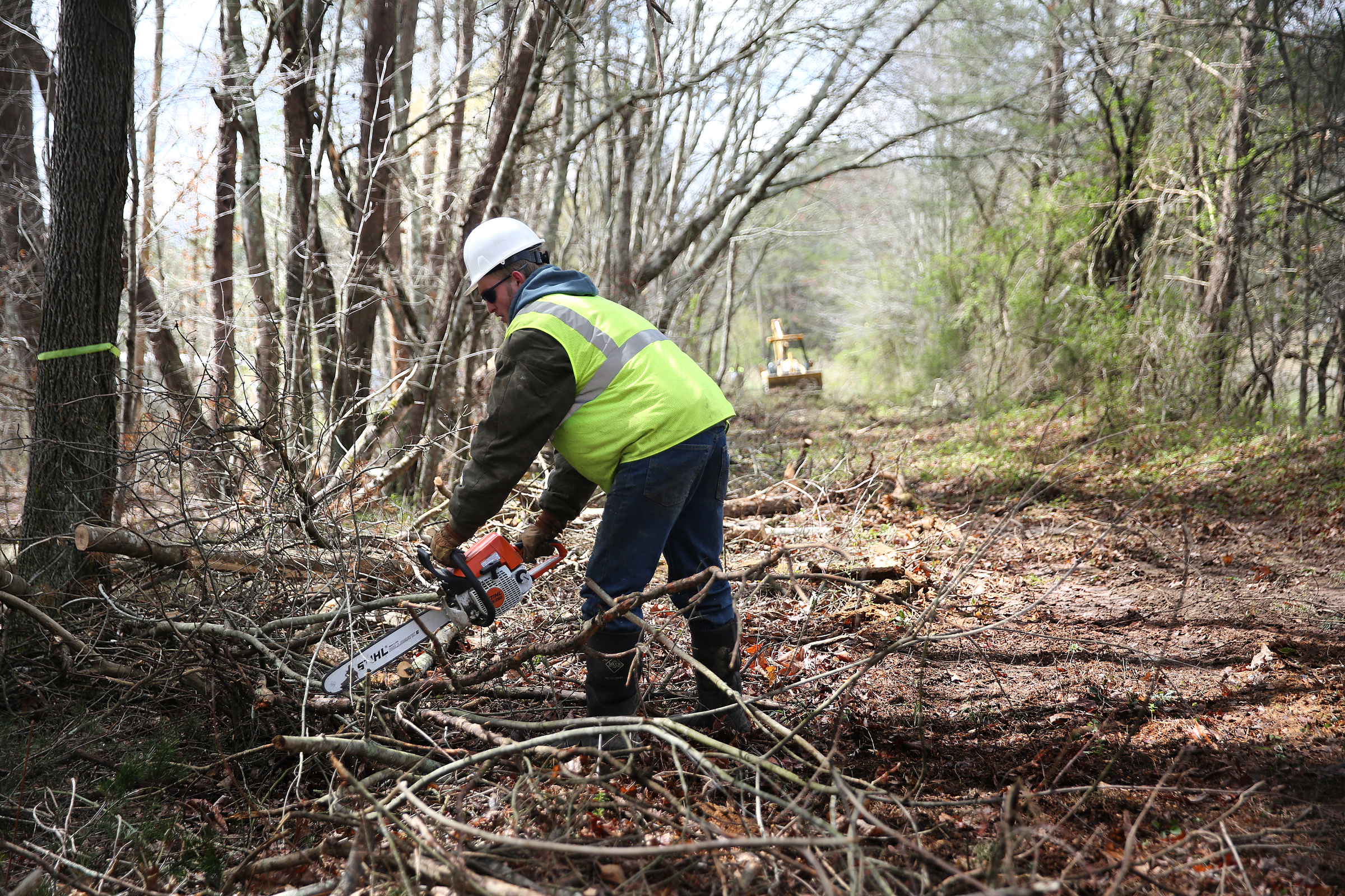 Daniel Brooks, a chainsaw operator with TREED and Associates, cuts up limbs along what will be part of the Mountain Goat Trail Wednesday, March 21, 2018 in Tracy City, Tenn. A multi-use walking and cycling trail connecting the communities along the path of the historic Mountain Goat Railroad has two ongoing construction projects as the area continues to develop the trail system.