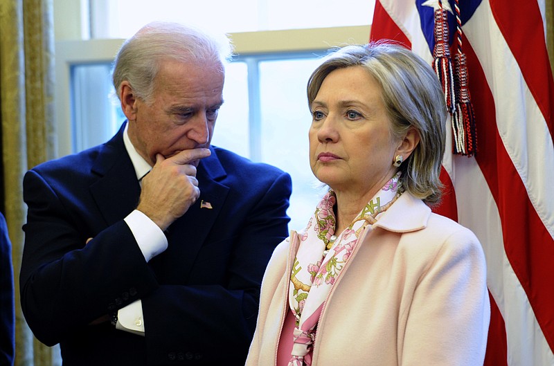 Then-Vice President Joe Biden takes a side glance at then-Secretary of State Hillary Rodham Clinton in the Oval Office of the White House in Washington, D.C., in 2009.