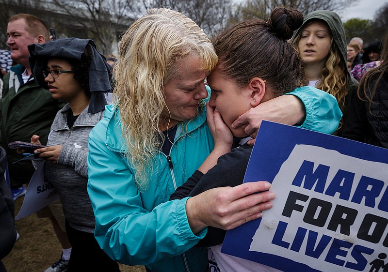 Brenda Myers, center, comforts her daughter Jamie, who is an Ooltewah Middle School student, during an emotional moment after a moment of silence at the March for Our Lives in Coolidge Park on Saturday, March 24, 2018, in Chattanooga, Tenn. Thousands of demonstrators marched locally in solidarity with national protests against gun violence spurred by last month's school shooting in Parkland, Fla.