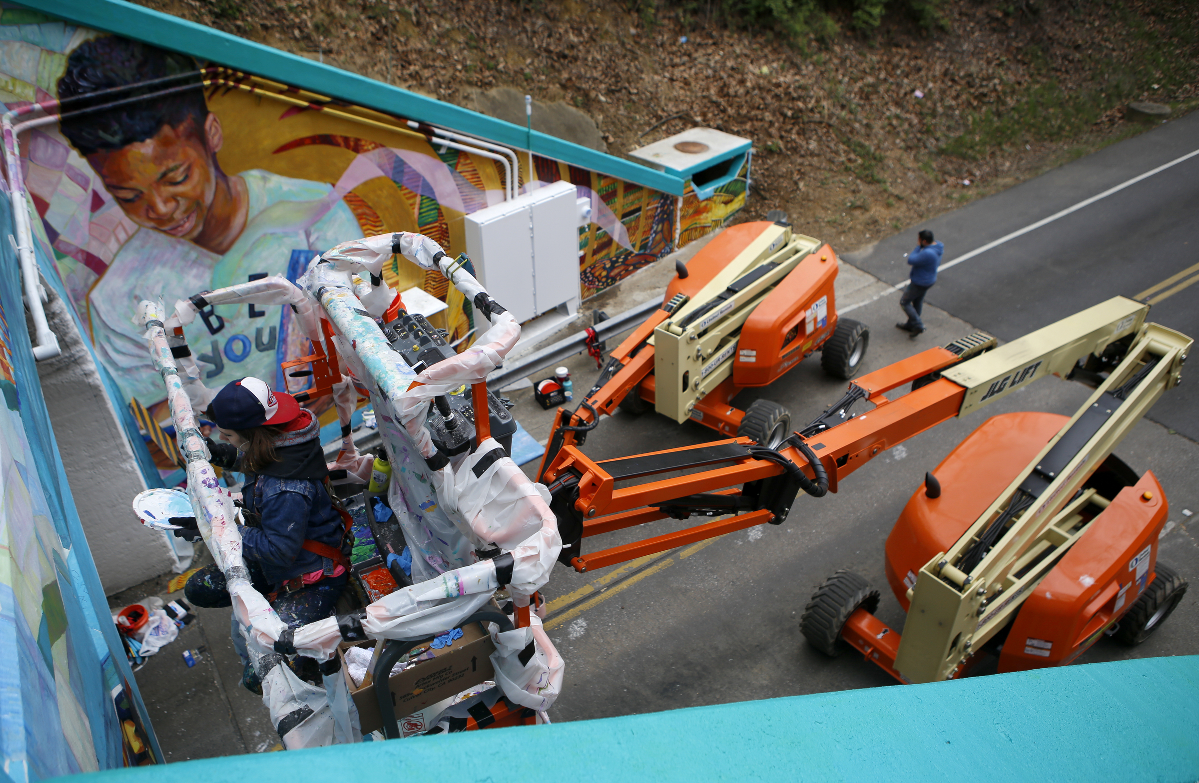 Greta McLain, left, works on painting over the seams of the mural on the east end of the Wilcox Tunnel on Monday, March 26, 2018 in Chattanooga, Tenn. McLain is the lead artist and owner of GoodSpace Murals out of Minneapolis.