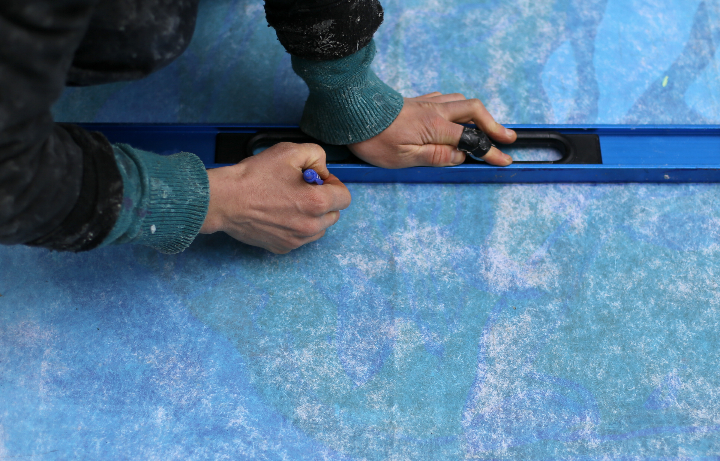 Eamonn McLain draws a guideline on the back of a section of the mural to go up on the west end of the Wilcox Tunnel on Monday, March 26, 2018 in Chattanooga, Tenn. McLain is a part of the GoodSpace Murals crew from Minneapolis.