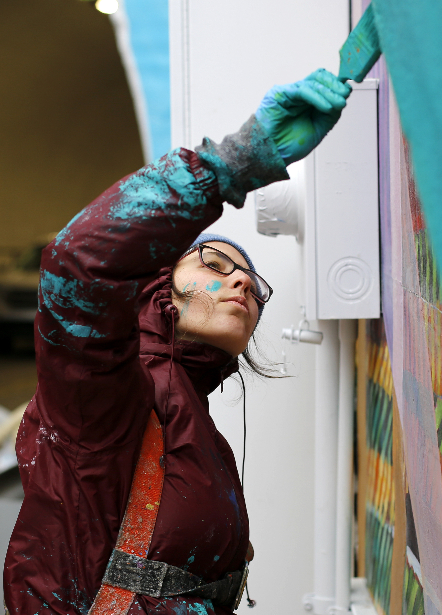 Local artist Mercedes Llanos works on painting on the top of the tunnel abutment on the east end of the Wilcox Tunnel on Monday, March 26, 2018 in Chattanooga, Tenn. Llanos was working with the GoodSpace Murals crew out of Minneapolis.