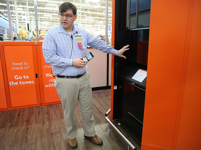Neal Beeler, a store manager, describes how the new pickup tower at Walmart works on Wednesday, March 27, 2018 in Ooltewah, Tenn. Standing at 16 feet tall and eight feet around, the tower has shelves inside that hold up to 300 pieces of ordered merchandise.