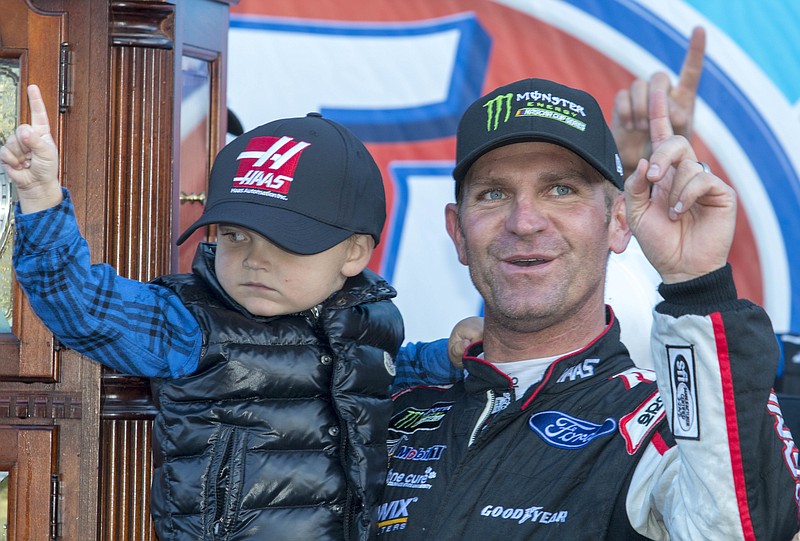 Clint Bowyer, right, celebrates after winning a NASCAR Cup Series auto race at Martinsville Speedway in Martinsville, Va., Monday, March 26, 2018. (AP Photo/Matt Bell)