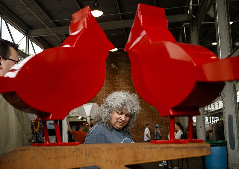 Emily Wilson looks at a sculpture by Dale Rogers at last year's 4 Bridges Arts Festival. Nearly 500 artists from across the country present their work at the nationally known festival, which returns April 21-22 for its 18th year.