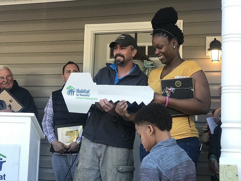 Habitat for Humanity's Senior Project Manager, Roy Jarvis, presents a mock key to Habitat's 278th homeowner, Shan Melvin, during a special dedication ceremony.