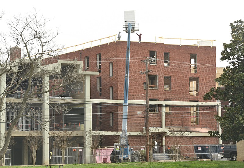 Construction workers guide a load of materials atop the Highland Park building of the future home of Chattanooga Prep School for boys. The building is located at 1849 Union Ave.