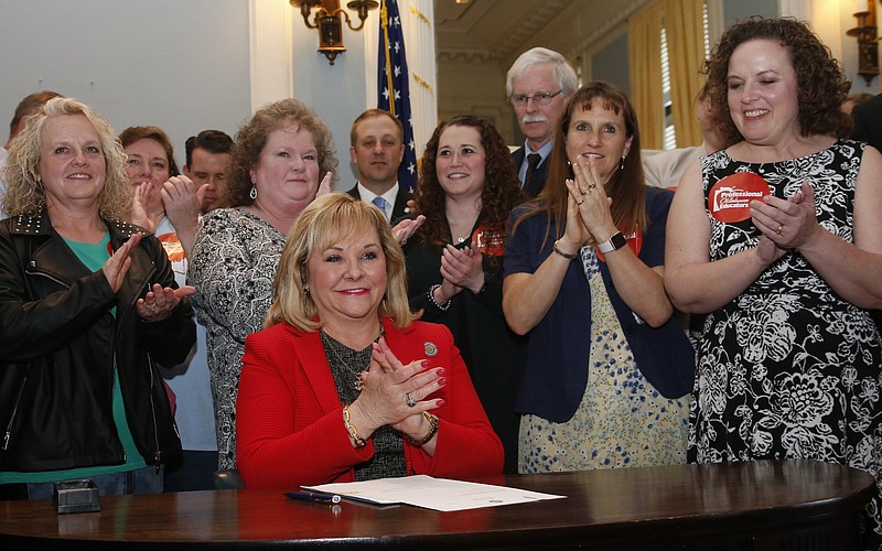 
              Surrounded by teachers and legislators, Oklahoma Gov. Mary Fallin applauds after signing a teacher pay raise bill in Oklahoma City, Thursday, March 29, 2018. (AP Photo/Sue Ogrocki)
            