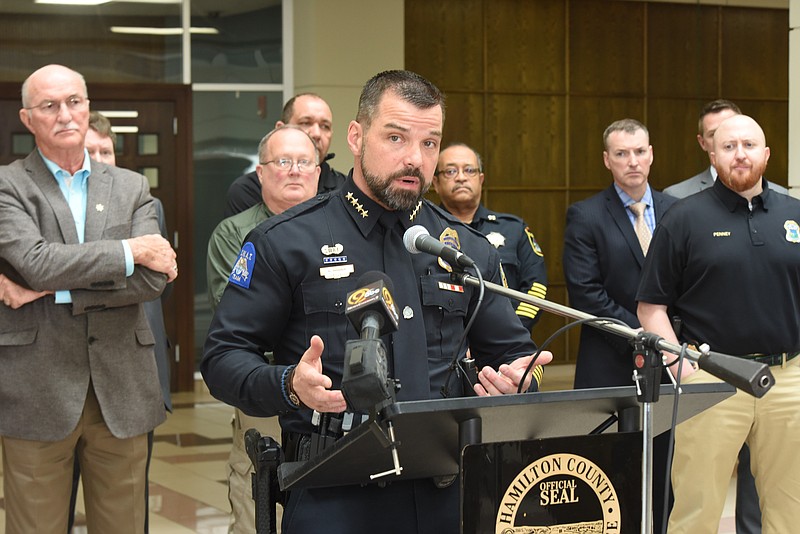 Flanked by Hamilton County Sheriff Jim Hammond, left, and several law officers, Chattanooga Police Chief David Roddy talks about the indictment of 54 gang members under the state's RICO Act.