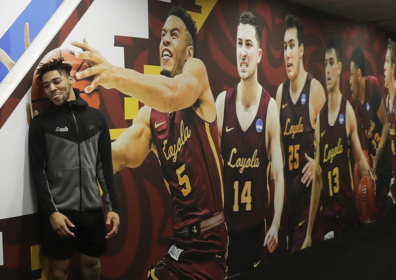 Loyola's Adarius Avery poses for a picture next to a photo on the wall after a practice session for the Final Four NCAA college basketball tournament, Thursday, March 29, 2018, in San Antonio. (AP Photo/Eric Gay)