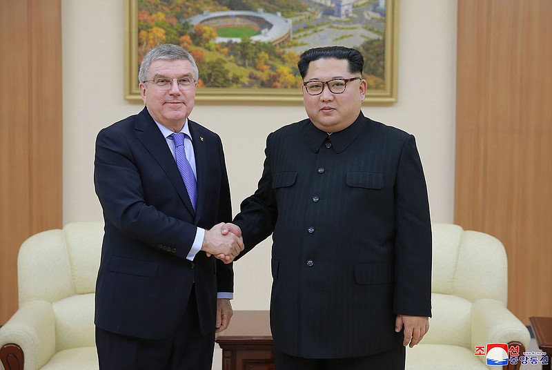 In this photo provided by the North Korean government on Saturday, March 31, 2018, North Korean leader Kim Jong Un, right, poses with International Olympic Committee President Thomas Bach for a photo during a meeting in Pyongyang, North Korea.