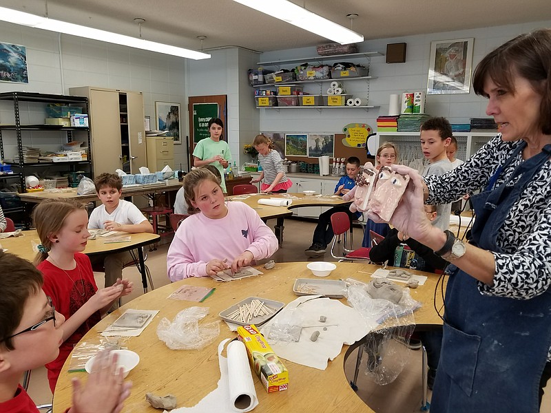 Thrasher Elementary art teacher Nancy Stagmaier teaches fifth-graders how to sculpt tile faces. Stagmaier's position is one of 12 at the three Signal Mountain public schools funded by the Mountain Education Foundation, which has experienced a recent decline in donations. (Contributed photo)