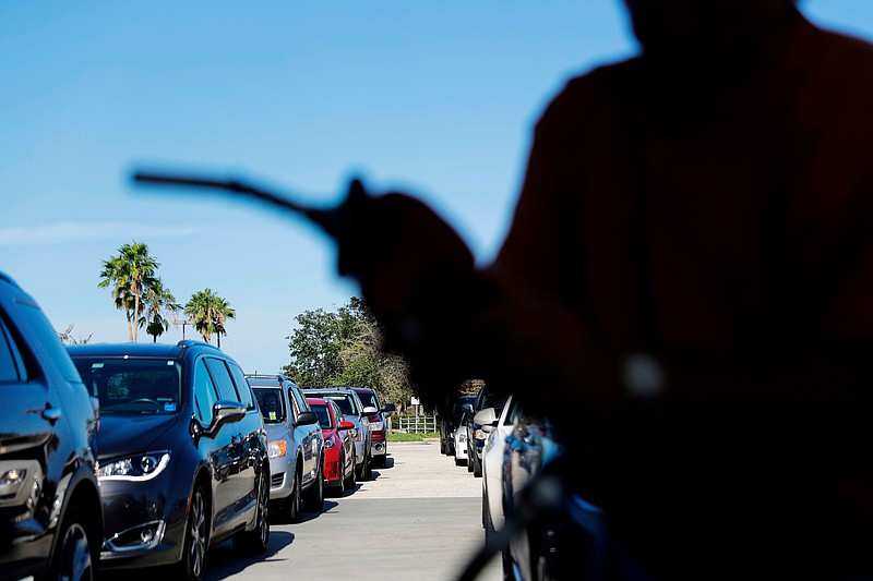 FILE- In this Sept. 13, 2017, file photo, cars wait in line for gas as a station in Miromar Lakes, Fla. Environmental regulators announced on Monday, April 2, 2018, they will ease emissions standards for cars and trucks, saying that a timeline put in place by President Obama was not appropriate and set standards “too high.” (AP Photo/David Goldman, File)