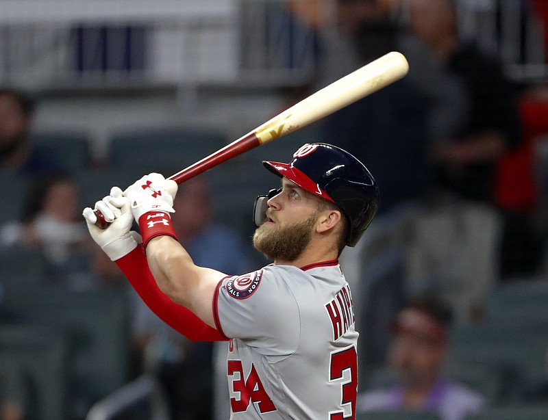 Washington Nationals right fielder Bryce Harper (34) follows through on a three-run home run in the second inning of a baseball game against the Atlanta Braves Monday, April 2, 2018, in Atlanta. (AP Photo/John Bazemore)