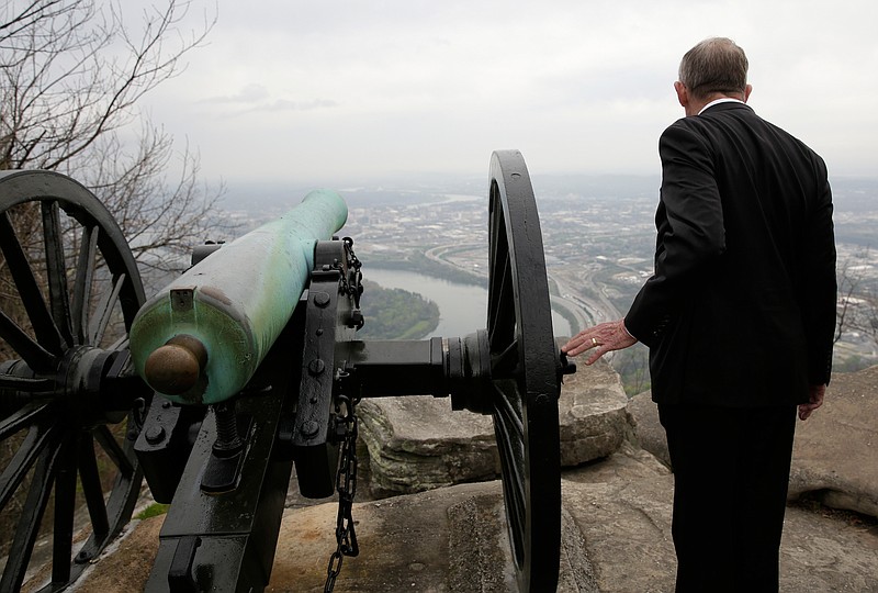 U.S. Sen. Lamar Alexander touches a cannon as he looks into the Chattanooga valley during a visit to Point Park on Tuesday, April 3, 2018, in Lookout Mountain, Tenn. Sen. Alexander visited the park to push for a bill that he says will help address maintenance backlogs at federal parks like Point Park.