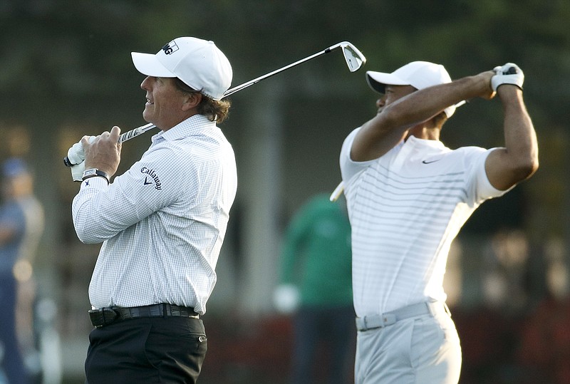 Phil Mickelson, left, and Tiger Woods warm up on the driving range during practice for the Masters golf tournament at Augusta National Golf Club, Tuesday, April 3, 2018, in Augusta, Ga. (AP Photo/Charlie Riedel)
