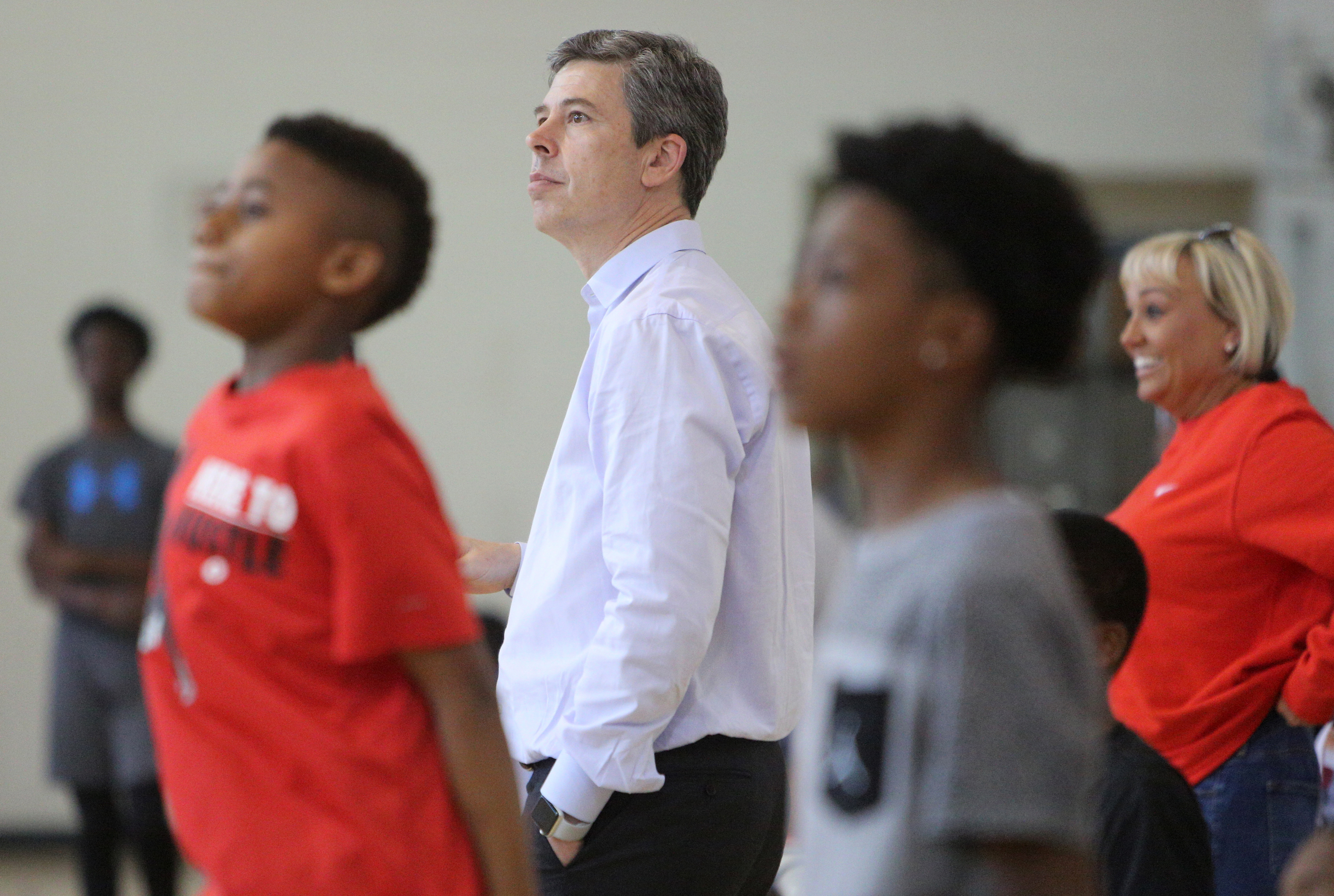 Chattanooga Mayor Andy Berke watches the 3-point competition from the sidelines with a few boys waiting their turn Wednesday, April 4, 2018 during the Inaugural YFD All-Star Game at the Brainerd YFD Center in Brainerd, Tenn. This celebration included a skills challenge, 3-point shootout, a dunk contest, as well as a basketball tournament coached by Berke.