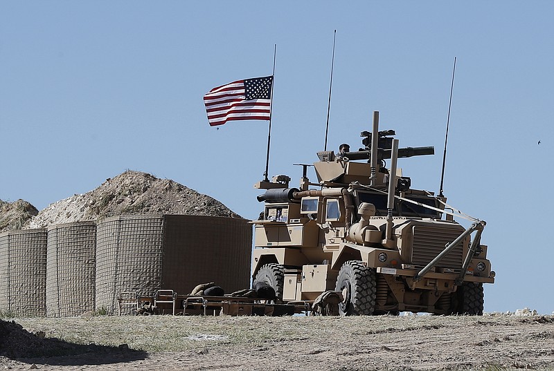 A U.S. soldier sits on an armored vehicle on a newly installed position, near the tense front line between the U.S-backed Syrian Manbij Military Council and the Turkish-backed fighters, in Manbij, north Syria, Wednesday, April 4, 2018. A week ago, there was just a single house where U.S. soldiers had hoisted a U.S. flag on a hill a little ways back from a tense front line in Syria. Now on Wednesday stood a growing outpost with a perimeter of large sand barriers and barbed wire, a new watch tower and half a dozen armored vehicles, The Associated Press found. (AP Photo/Hussein Malla)