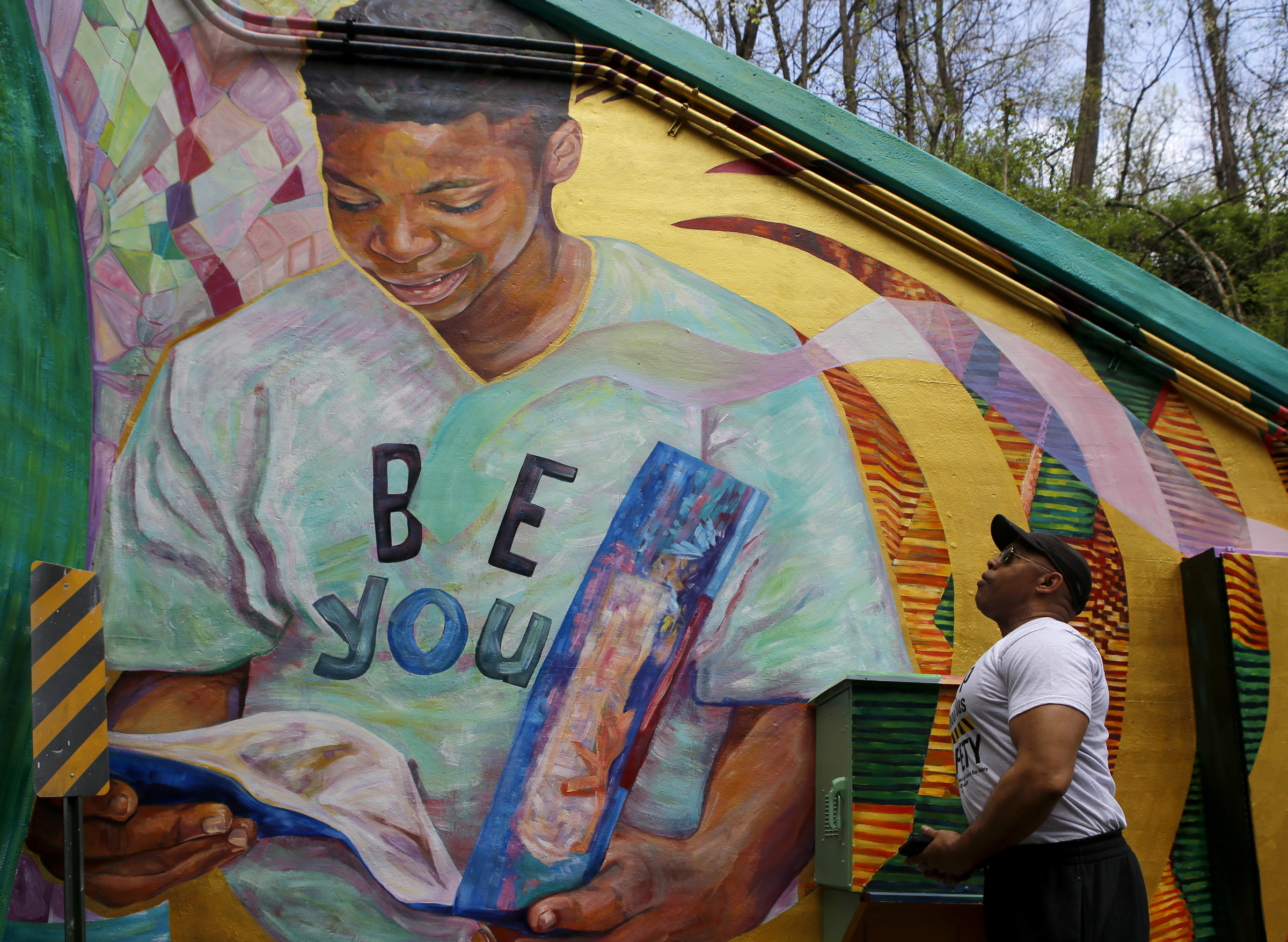 Dank Hawkins, the facility manager at Eastdale Youth and Family Development Center, looks for familiar faces on the mural on the east end of the Wilcox Tunnel.