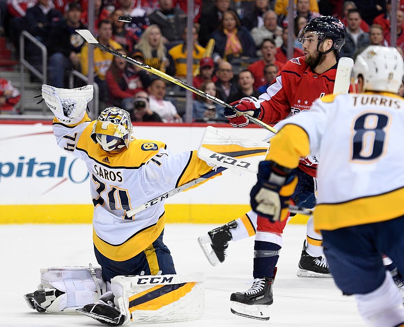 Washington Capitals right wing Tom Wilson, top right, vies for the puck against Nashville Predators goaltender Juuse Saros (74) during the second period of an NHL hockey game Thursday, April 5, 2018, in Washington. (AP Photo/Nick Wass)