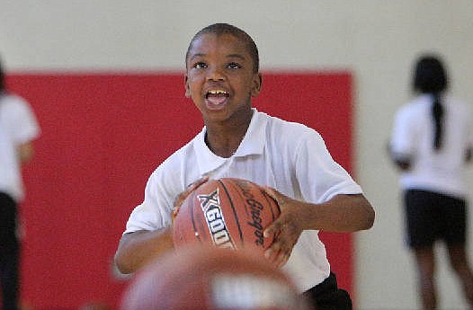 Christion Gearing, 10, shoots a ball as another falls through the hoop during the 3-point competition Wednesday, April 4, 2018 during the Inaugural YFD All-Star Game at the Brainerd YFD Center in Brainerd, Tenn. A few hundred children filled the gym Wednesday night to participate in the event.