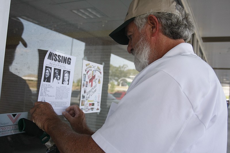 Staff Photo by Allison Carter/Chattanooga Times Free Press - Jun 13, 2011 - Bob Sluder, Marsha Brantley's cousin, tapes up a flier Monday on the window of a vacant store in Cleveland, Tenn. Brantley, a Cleveland resident, has been missing for 2 years. 