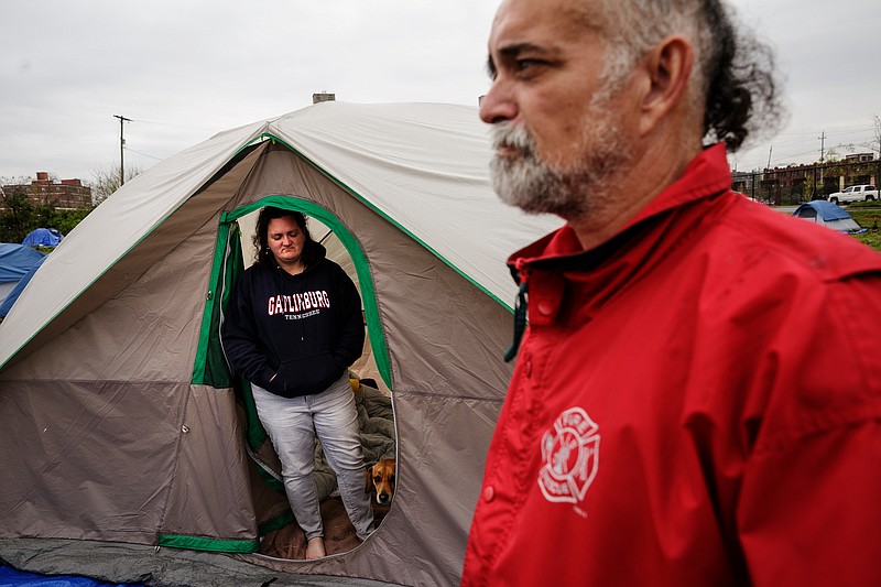 Keim Shirley, right, and Tracy Corello stand outside the tent they share in a homeless encampment behind the city's wellness center on East 11th Street on Friday, April 6, 2018, in Chattanooga, Tenn. City service coordinators were on site at the camp Friday to help residents find temporary housing, because the camp is located on a toxic brownfield. 