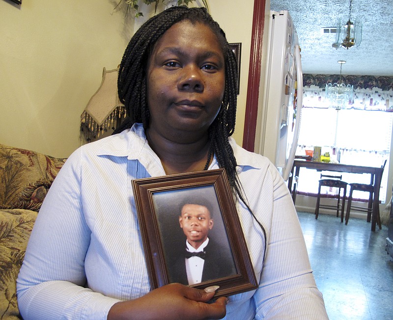 
              This April 5, 2018 photo shows Jameillah Smiley holding a framed photograph of her son, Ricky Boyd, at her home in Savannah, Ga. Police fatally shot Boyd on Jan. 23, 2018, after coming to his home to arrest him on a murder charge. The Georgia Bureau of Investigation has said Boyd raised a BB gun that looked like a handgun before officers shot him. Smiley and other family members insist Boyd was completely unarmed. (AP Photo/Russ Bynum)
            