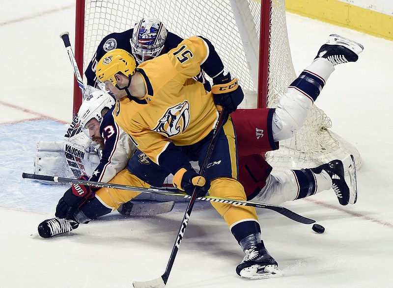 Nashville Predators left wing Austin Watson (51) and Columbus Blue Jackets defenseman Ian Cole (23) battle for the puck in front of Blue Jackets goaltender Joonas Korpisalo, top, of Finland, during the first period of an NHL hockey game Saturday, April 7, 2018, in Nashville, Tenn. (AP Photo/Mark Zaleski)