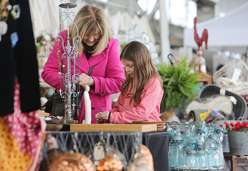 Debby Weaver and her 8-year-old granddaughter Cosie Weaver look through items at the Retro Rosa booth Sunday, April 8, 2018 during Vintage Market Days event at the First Tennessee Pavilion in Chattanooga, Tenn. Cosie said her favorite items she had seen so far were a watch with the Eiffle Tower on it and a flower sifter. The two thought it was fun to see so many things that their parents or grandparents owned or still own at the event. 