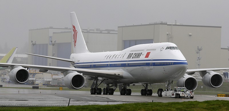 FILE-  In this Sept. 29, 2014, file photo, the first Boeing 747-8 Intercontinental airplane to be delivered to Air China is moved into position from Boeing's assembly facility to Paine Field in Everett, Wash. In their escalating conflict over trade, what the U.S. and China are leaving off their tariff lists tells as much as what’s on the lists. China put smaller planes on its list, but excluded the 747 and other big planes made in the U.S. by Boeing Co. (AP Photo/Ted S. Warren, File)