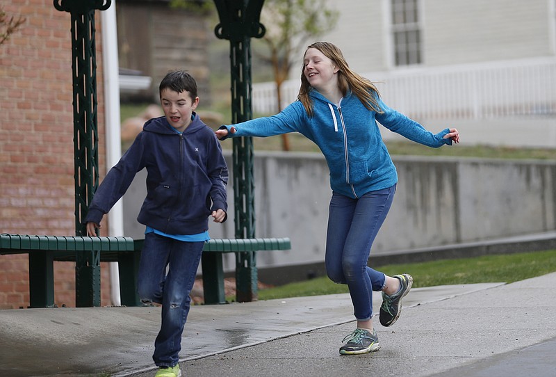 In this April 6, 2018, photo, Caleb Coulter, 10, left, and his sister Kendra, 12, play tag during a visit to the Place Heritage Park in Salt Lake City.