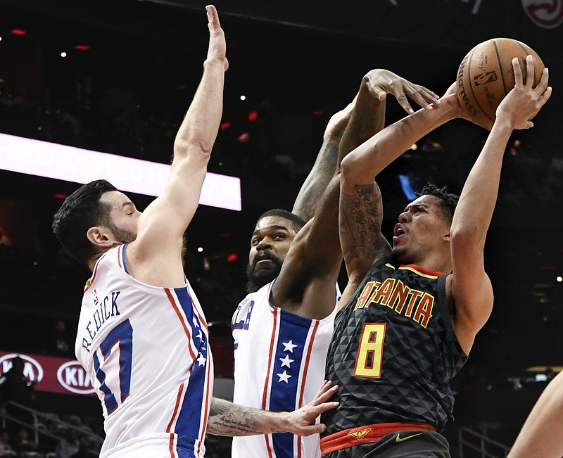 Atlanta Hawks guard Damion Lee (8) shoots as Philadelphia 76ers guard JJ Redick (17) and center Amir Johnson defend during the first half of an NBA basketball game Tuesday, April 10, 2018, in Atlanta. (AP Photo/John Amis)